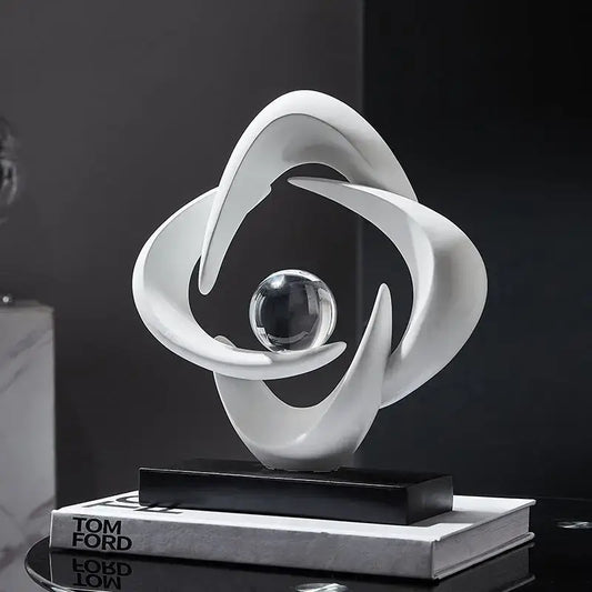 Modern white abstract resin sculpture figurine with flowing curves encircling glass sphere on black base decorbites abstract resin decor