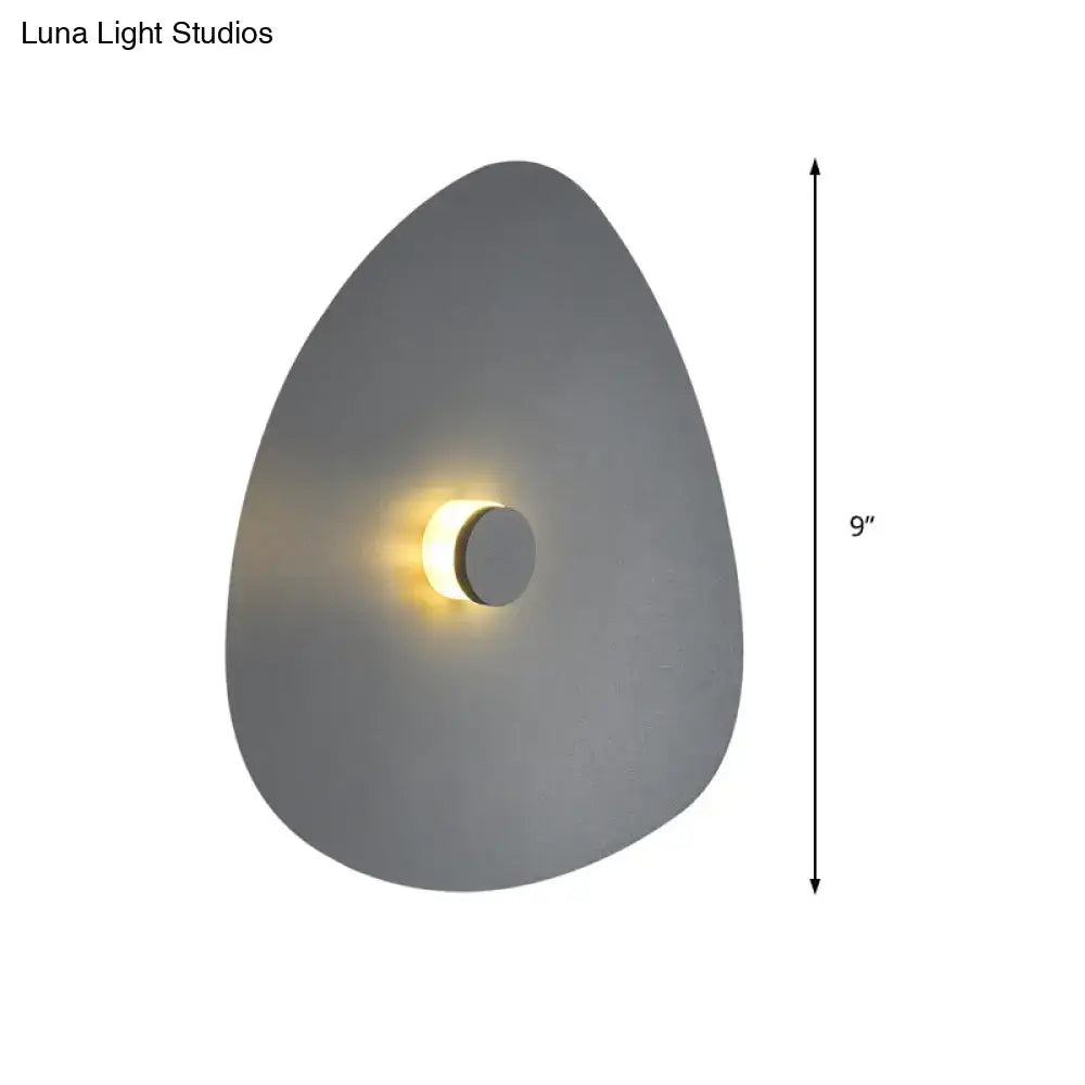 Modern gray teardrop-shaped flaky sconce light with warm circular center light for bedroom wall fixture