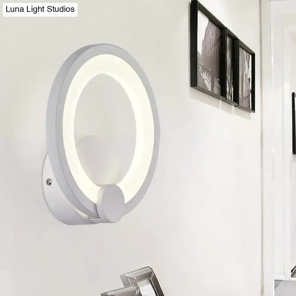 Modern white acrylic sconce light featuring a circular glowing ring and sleek minimalist design for bedroom walls