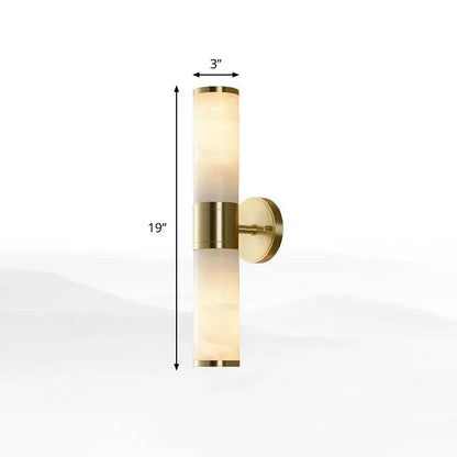 Modern white and brass pillar shaped sconce light with alabaster shade and brushed brass accents bedside wall lamp