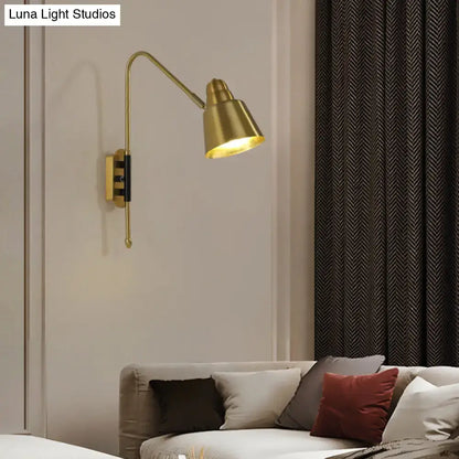Modern white and brass v-shaped wall light with gold-toned brass articulated arm and conical shade for bedroom reading