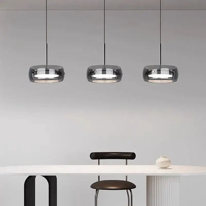 Three sleek modern pendant lights with dark smoked glass shades and remote dimming for minimalist dining rooms
