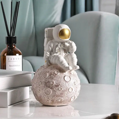 Modern white and gold decorbites astronaut phone holder figurine seated on textured moon surface for living room decor