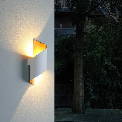Modern white and gold outdoor wall lamp with a warm curved design and gold-toned interior spiral sconce