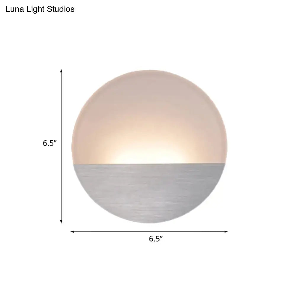 Modern white and silver led sconce light with matte frosted glass and brushed metal emitting warm glow for bedroom