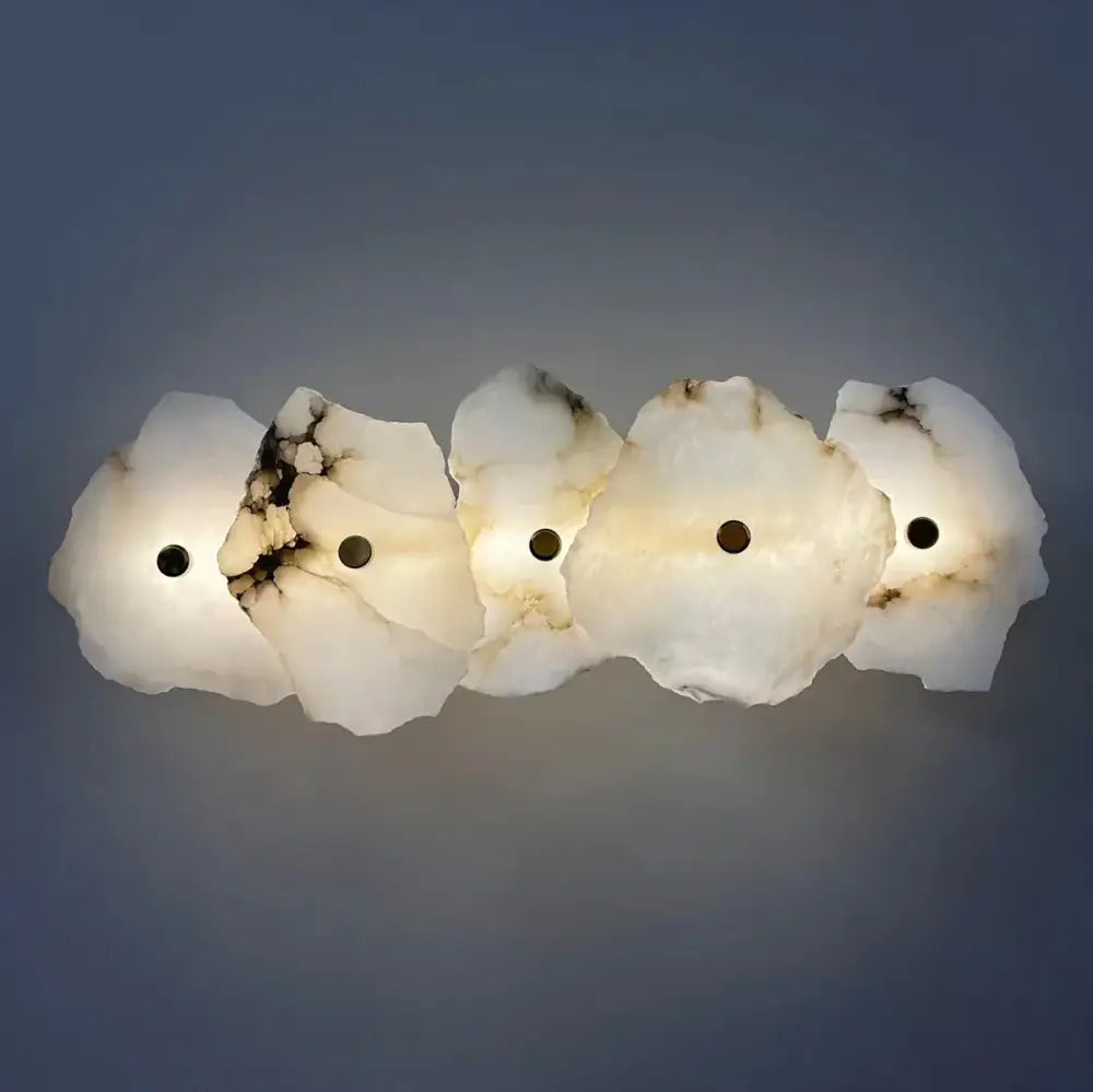 A modern five-piece wall lamp crafted from white and black veined alabaster with a smooth organic design brass wall lamp