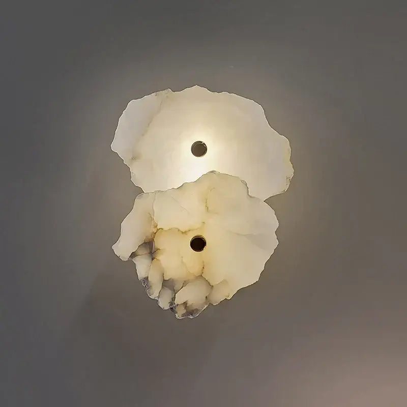 Modern white and black alabaster wall lamp with organic shell contours and dark accent by decorbites brass marble