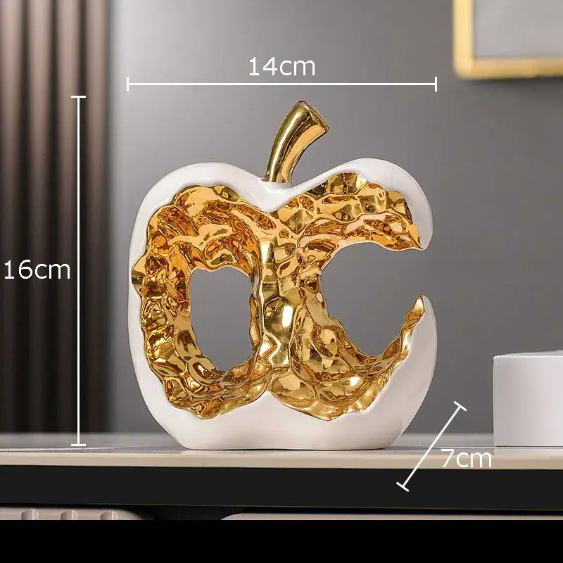 Modern white ceramic apple sculpture with metallic gold interior and stem for desk decoration and living room decor