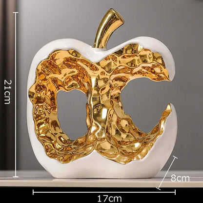 Modern white ceramic apple sculpture with textured metallic gold interior and stem for desk decoration or living room display