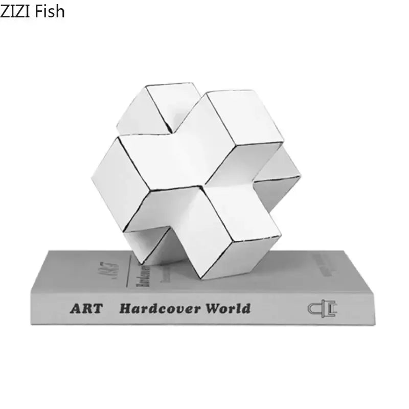 Modern white geometric cube block sculpture resting on gray art hardcover world book for living room decor