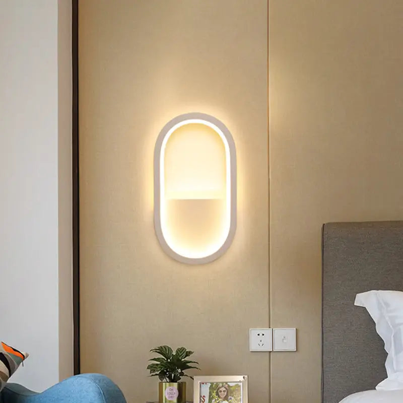 Modern wall lamp with oval white frame and warm white diffused led lighting for bedroom use