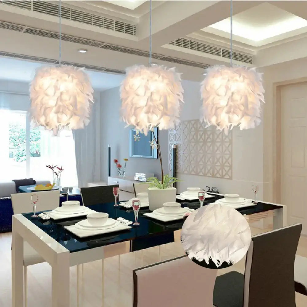 Three elegant white feather pendant lights hang above a modern dining table in a white and black bedroom cloud design
