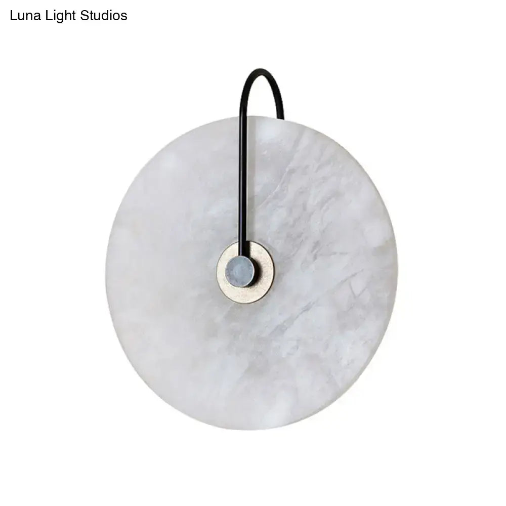 Modern white and black led wall sconce with marble disc shade and black metal arm for bedroom lighting