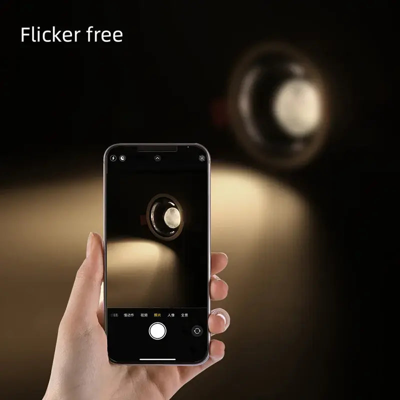 A sleek black smartphone held in hand displays a light source photo of decorbites 12w modern white and black recessed downlight spotlights