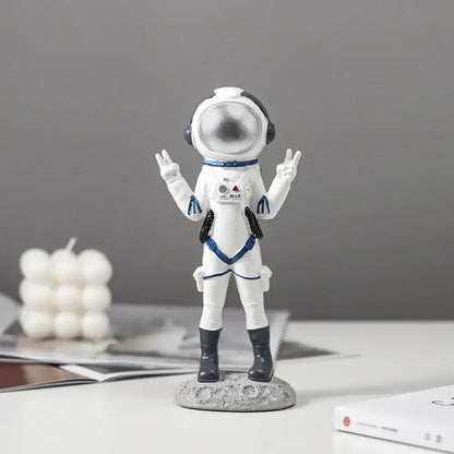 Modern white and blue astronaut resin figurines with silver helmet standing on textured gray lunar surface base decorbites astronaut resin
