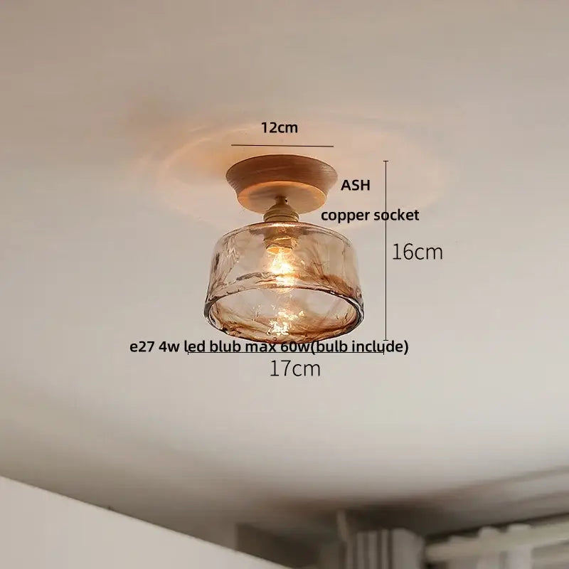 A warm-toned amber glass pendant light with copper socket and wooden base for modern ceramic led ceiling lamp use