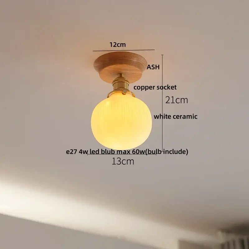 A warm glowing white ceramic led ceiling lamp with brass copper socket and ash wood mount for bedroom use