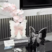 Modern white butterfly ceramic vase with pink bow accent and delicate pink orchid flowers for bedroom decorbites butterfly ceramic