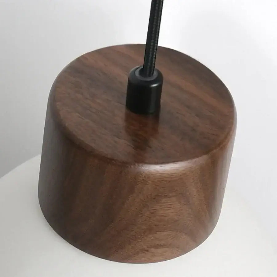 Modern white ceramic and dark brown wooden pendant light fixture with black cable for kitchen decor