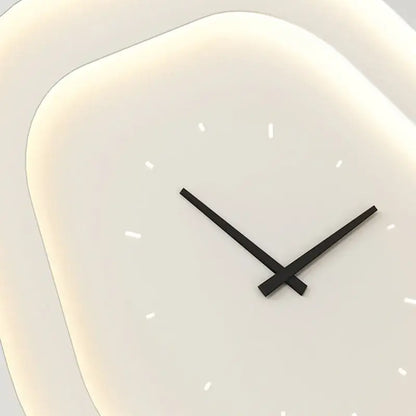 Modern minimalist wall clock with soft white rounded square face and sleek black hands paired with led wall lamp