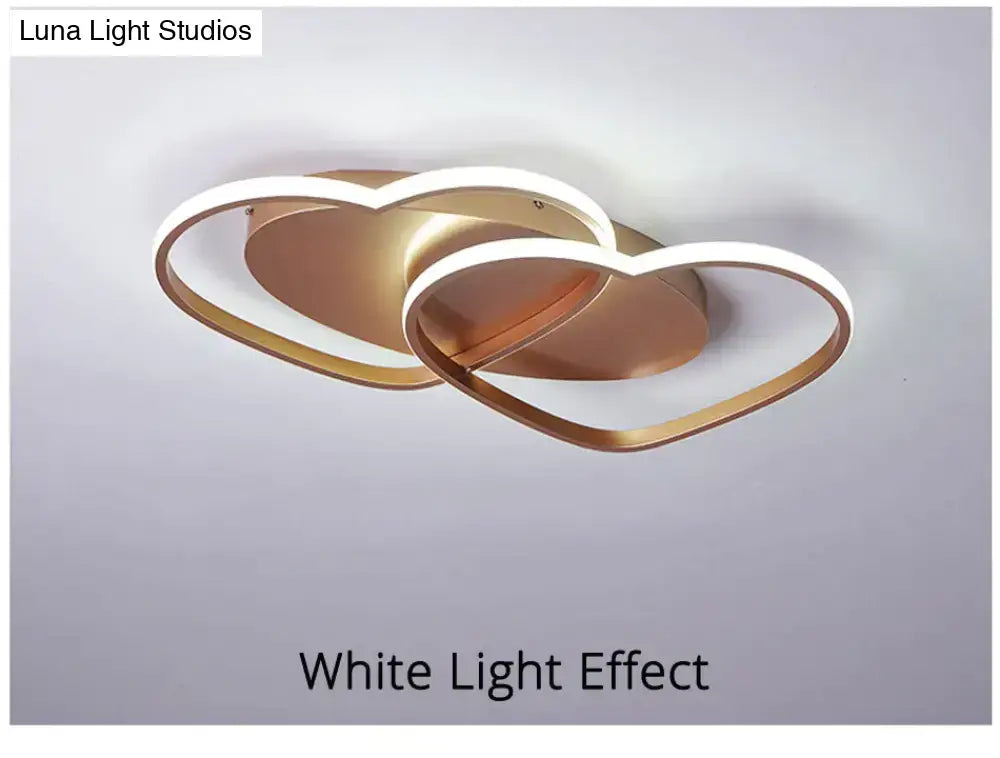 Modern white coffee pendant light featuring a gold-toned led fixture with interlocking heart-shaped rings and illuminated edges