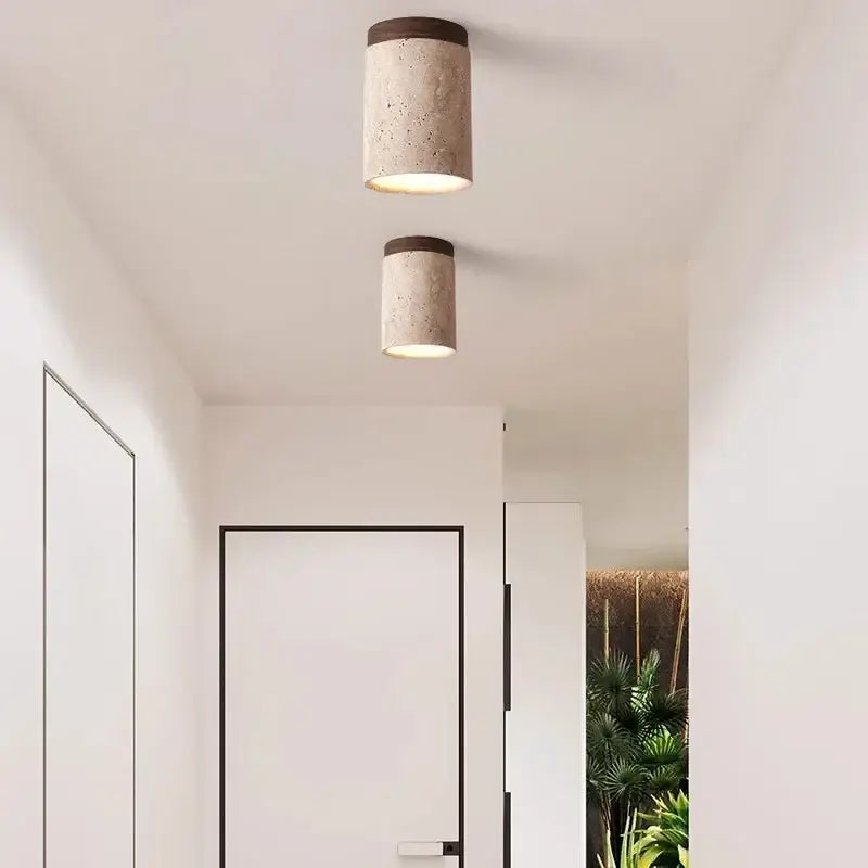 Two cylindrical white concrete pendant lights with dark wood accents for modern kitchen lighting area under square meters