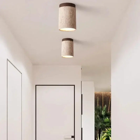 Two cylindrical white concrete pendant lights with dark wood accents for modern kitchen lighting area under square meters