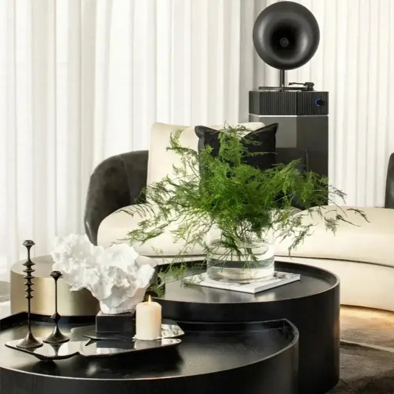 Black cylindrical coffee table with glossy finish paired with decorbites coral tree resin sculpture for home decor