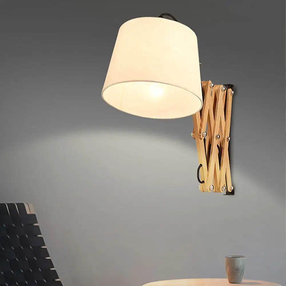 Modern white fabric wall lamp with a warm-toned cylindrical shade and wooden extendable arm for living room lighting