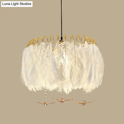 Modern white feather chandelier with gold-toned metal frame and decorative bird charms for living room pendant light