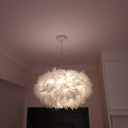 Modern white feather pendant light with soft white feathers and chrome finish hanging as a bedroom pendant light