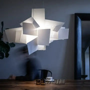 Modern white geometric pendant lamp with layered angular panels casting a soft glow decorbites big bang stacking design
