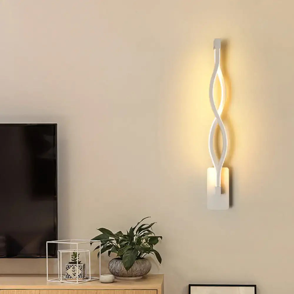 Modern white geometric wall lamp with twisted design emitting warm light for stairway illumination