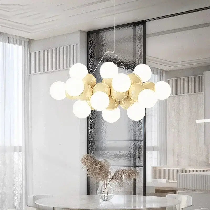 Modern white glass globe pendant light fixture with glossy white and gold spherical bulbs on a minimalist metal frame