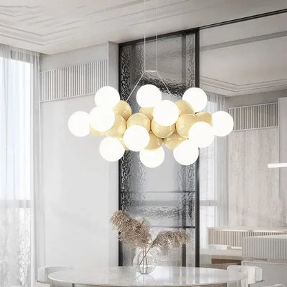 Modern white glass globe pendant light fixture with glossy white and gold spherical bulbs on a minimalist frame for dining room