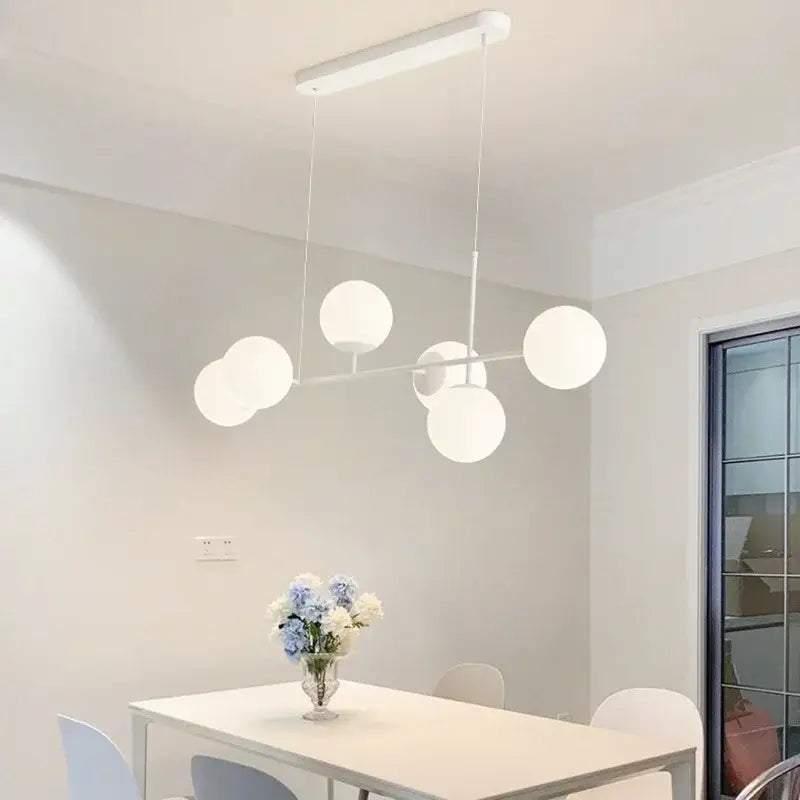 Modern white glass pendant chandelier light set featuring spherical frosted glass shades for dining room lighting