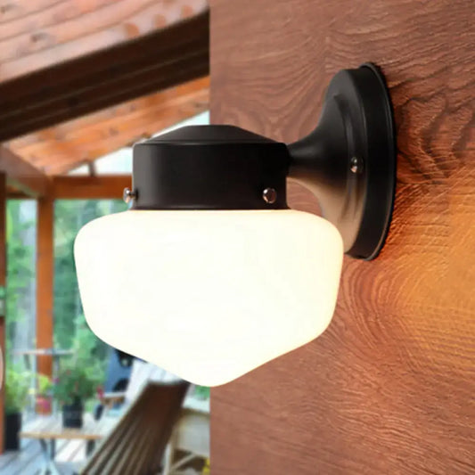 Black metal sconce light with frosted modern white glass shade designed for bedroom near black white mirror