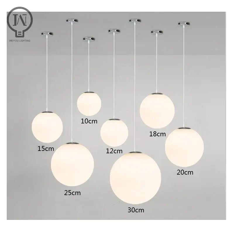 Set of modern spherical pendant lights with white globe shade in frosted glass and chrome fixtures for kitchen and dining room