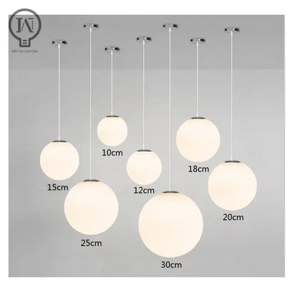 Set of modern spherical pendant lights with white globe shade in frosted glass and chrome fixtures for kitchen and dining room