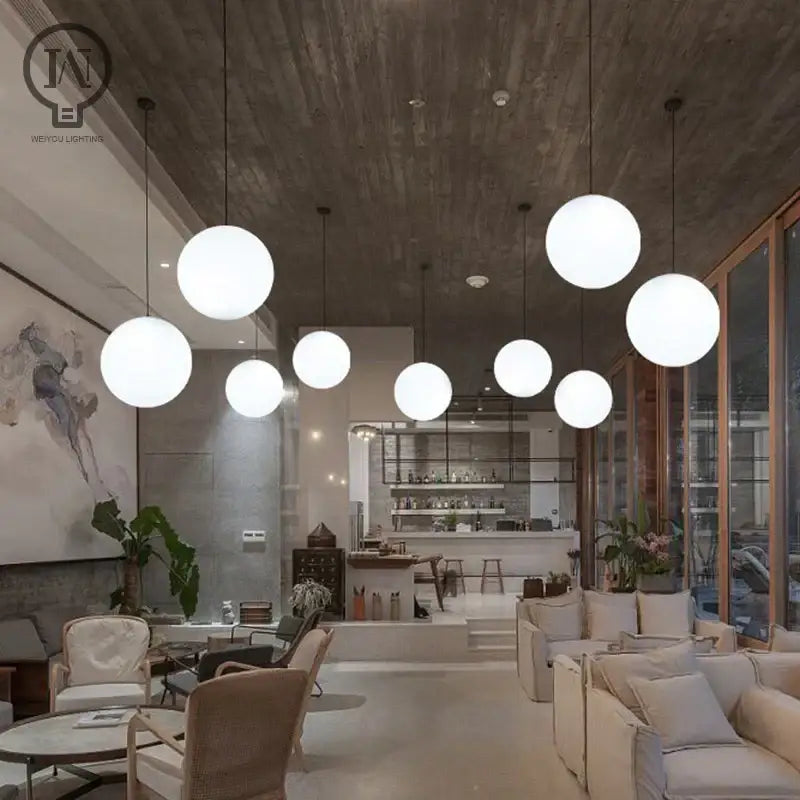 Modern white globe pendant light with white globe shade glass fixture hanging in kitchen dining room ceiling