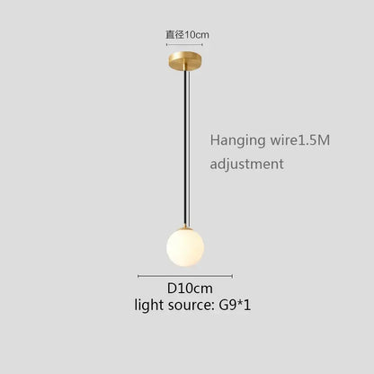 Modern pendant light with gold finish, white globe shade, matte glass globe, and black hanging wire for kitchen and dining room
