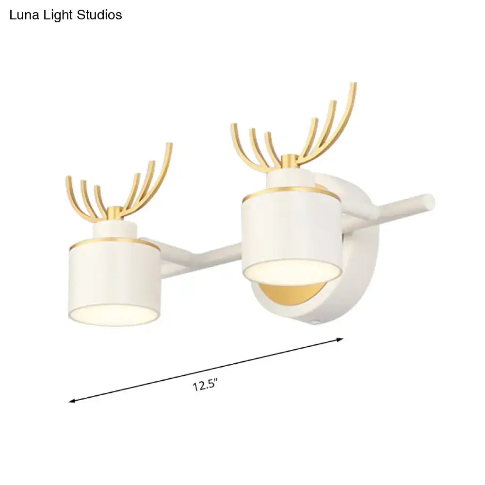 Modern white and gold deer-themed wall light fixture with two cylindrical LED shades for bathroom vanity use