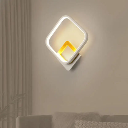 Modern white and gold wall sconce minimalist with a warm white glowing yellow inner frame for bedroom lighting
