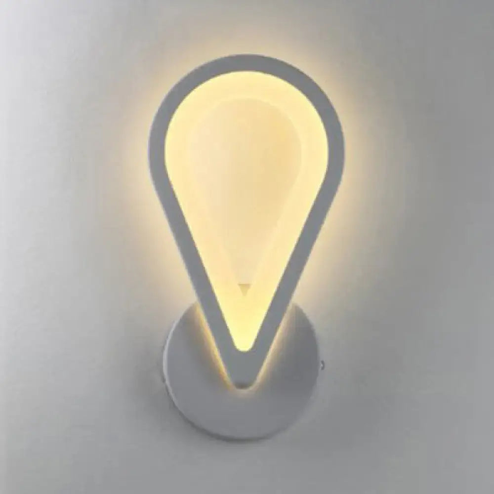 Modern white heart led wall sconce with sleek teardrop design emitting warm yellow light for minimalist bedroom lighting