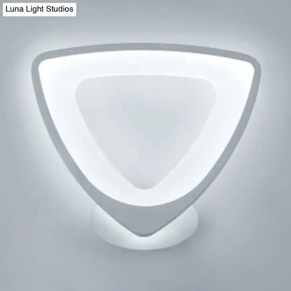 Modern white heart led wall sconce with sleek white acrylic and matte gray metal frame emitting soft ambient light
