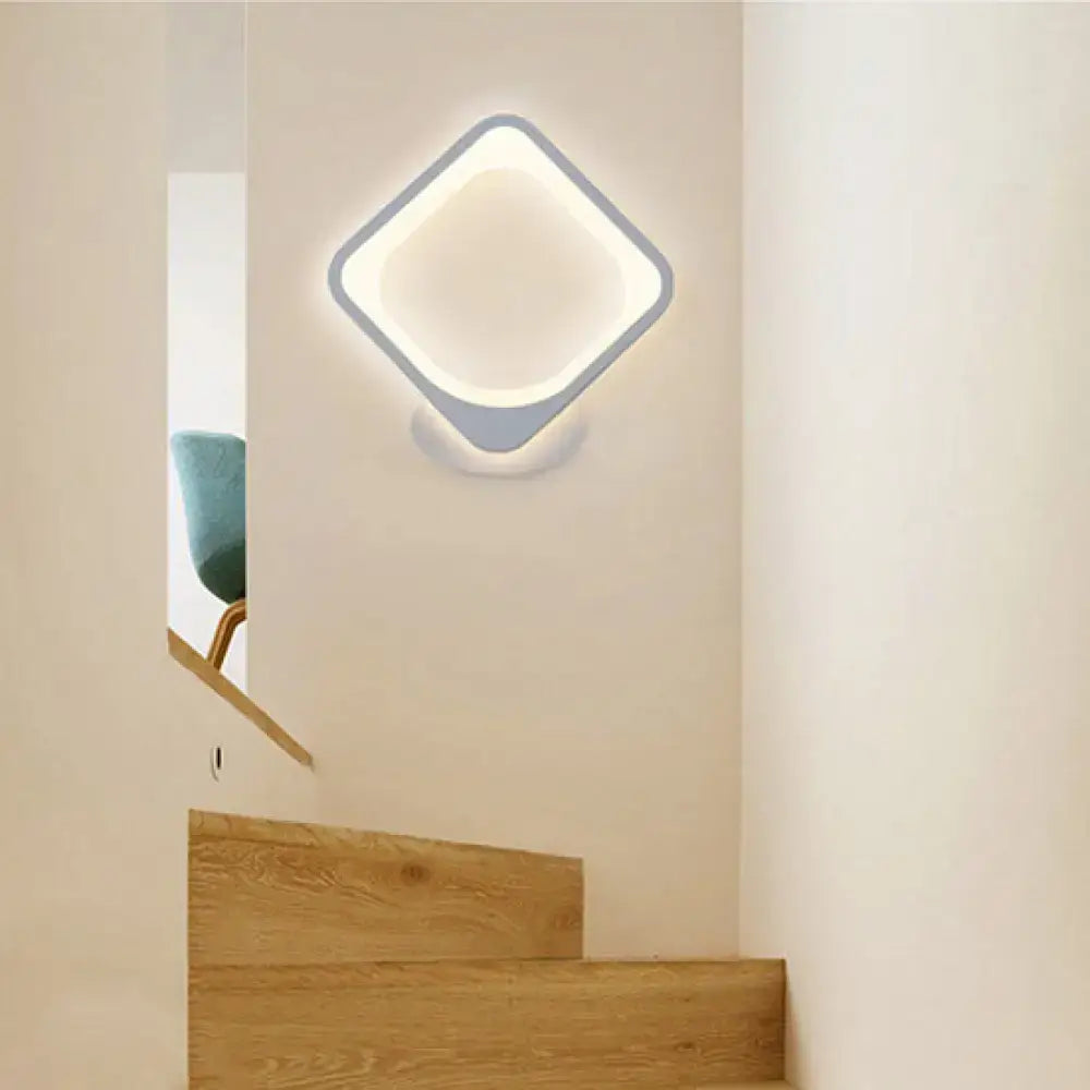 Modern white heart led wall sconce with diamond-shaped light gray frame emitting soft ambient bedroom lighting