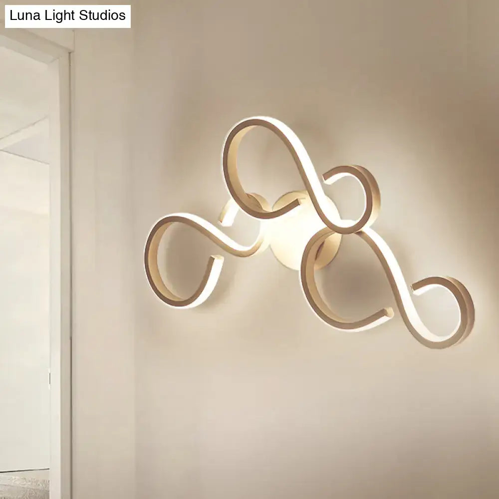 Modern gold-toned led wall sconce with flowing intertwined loop design includes bulb and features energy-efficient led light type