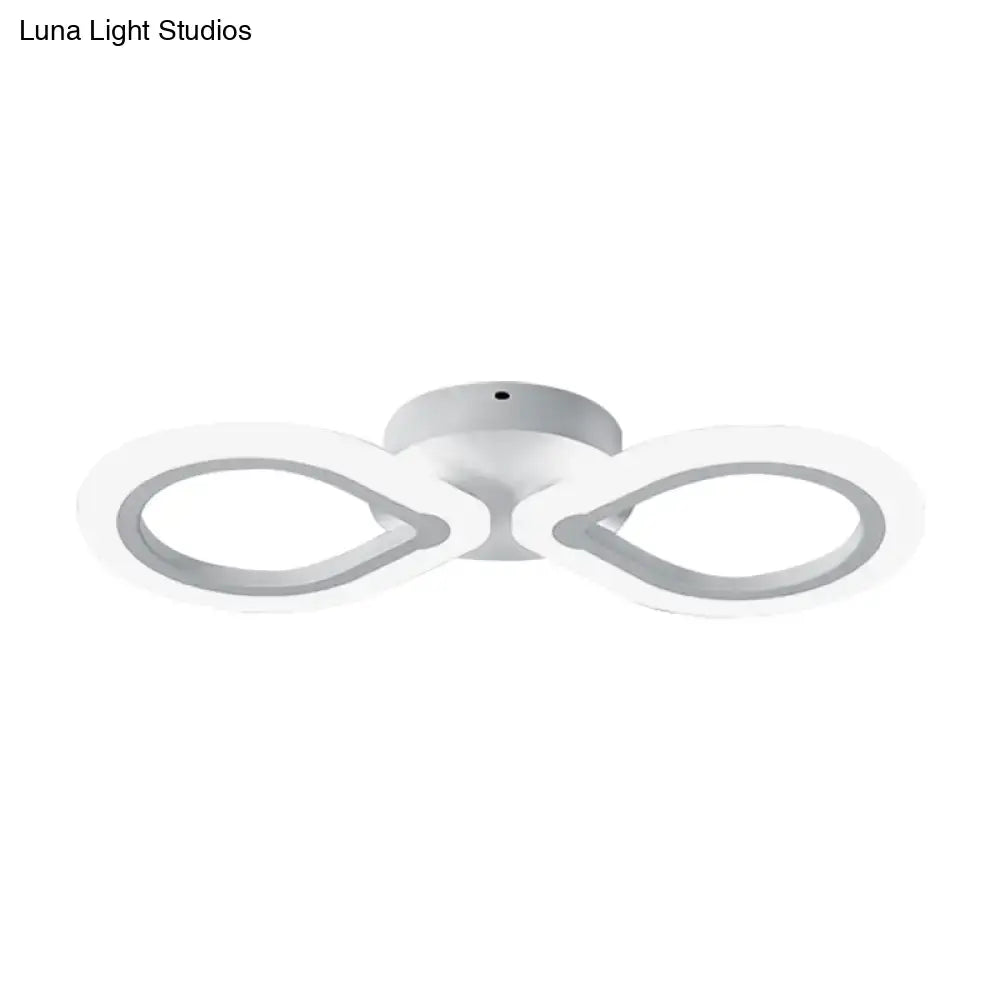 Modern white led wall light fixture with simple design featuring two interlocking infinity rings and bulb base