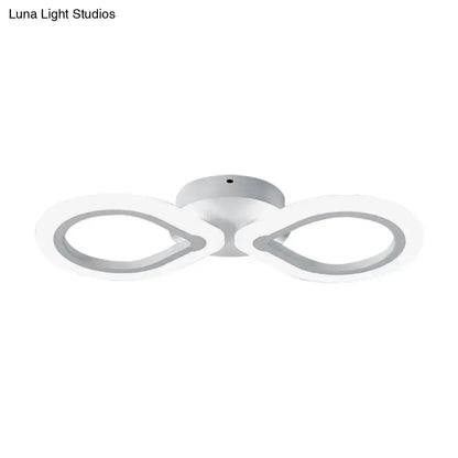 Modern white led wall light fixture with simple design featuring two interlocking infinity rings and bulb base