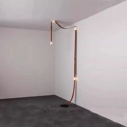 A sleek copper-toned leather-wrapped led wall sconce with minimalist design for decorbites designer belt marble pendant lights